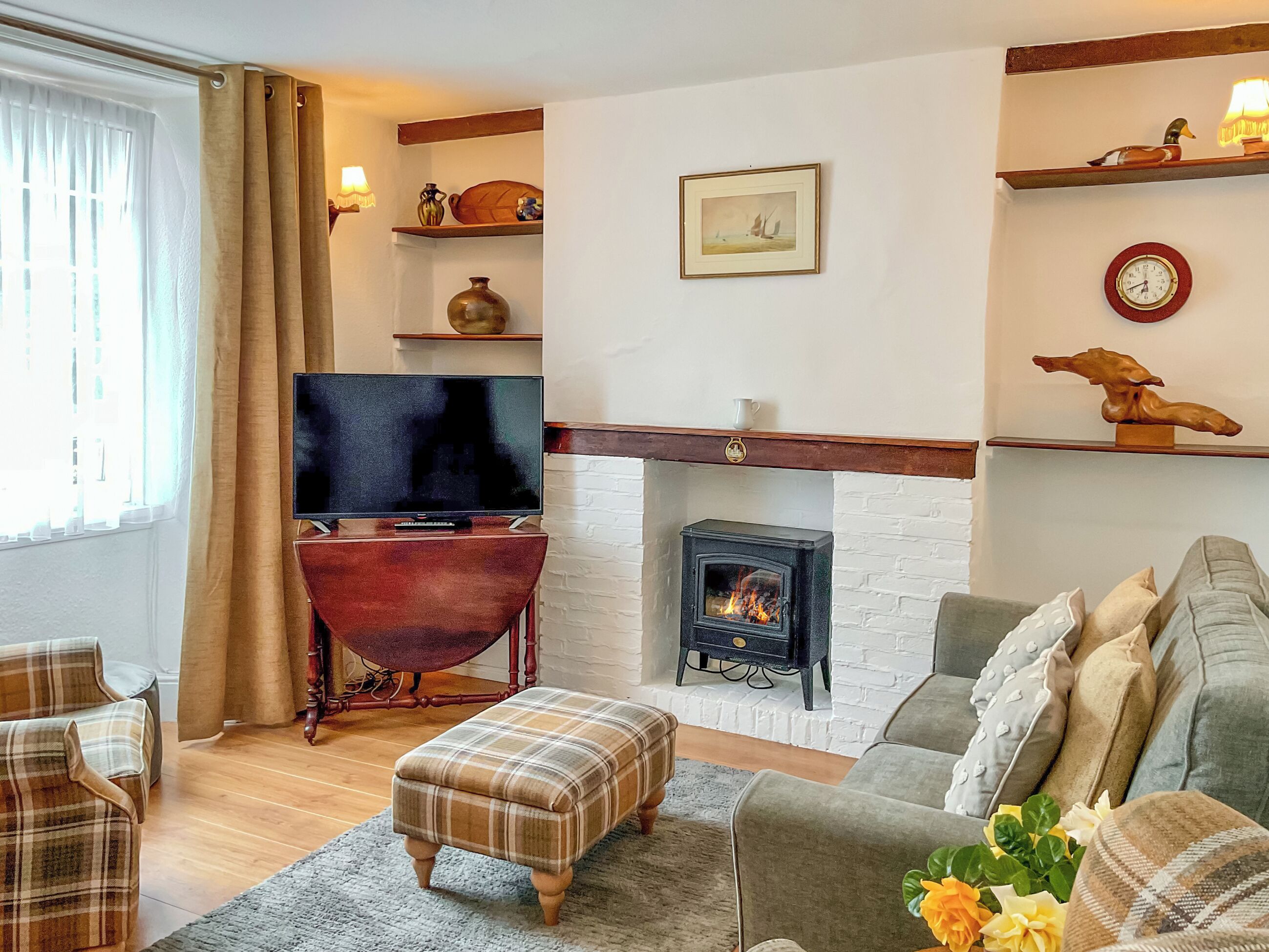 Un salon chaleureux avec une cheminée, un téléviseur et un canapé confortable.