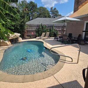 A backyard with a swimming pool, patio furniture, and a wooden fence. - GameDay! University of South Alabama Poolside Getaway🇺🇲Veteran Own ⚓️ (Mobile)
