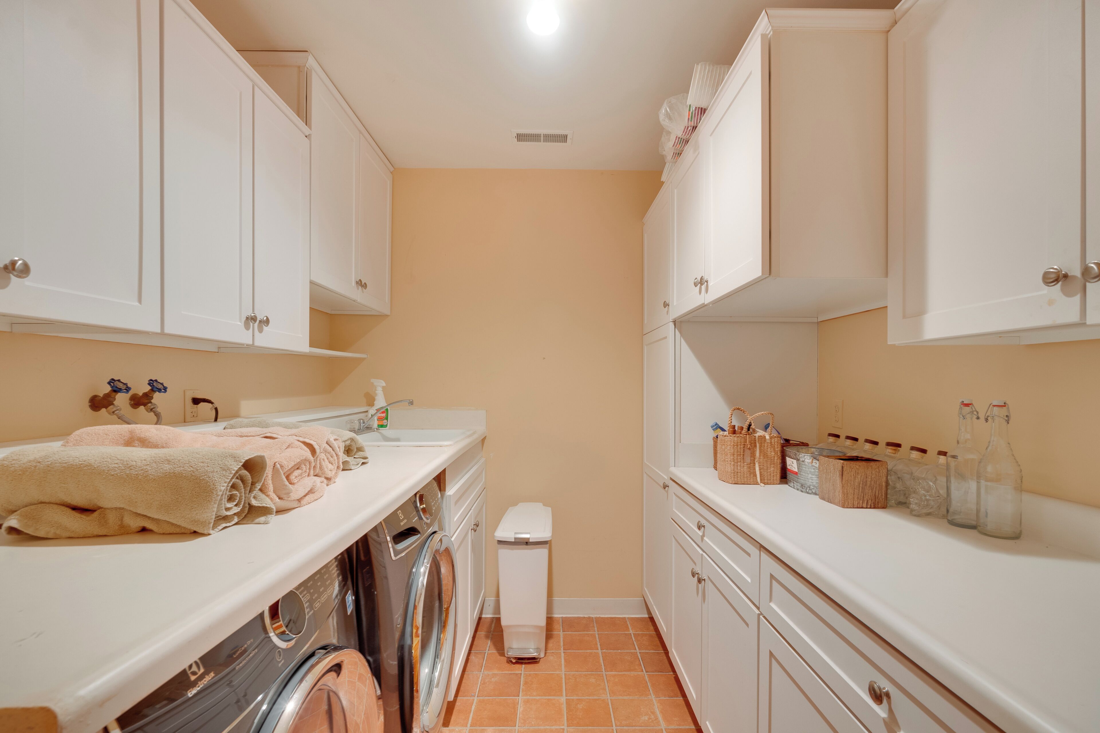 A compact laundry room with a washing machine, dryer, and stacked towels.
