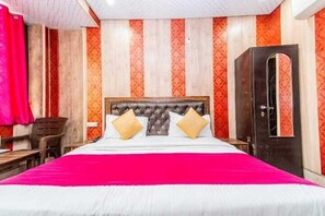 Ein Hotelzimmer mit einem großen Bett, einem hölzernen Kopfteil und einem roten Vorhang.