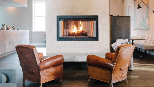 Una sala de estar moderna con chimenea, sillones de cuero, un sofá y un comedor.
