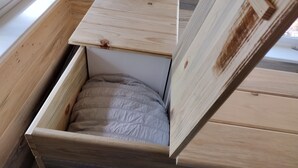 A compact wooden room with a bed, a small table, and a window.