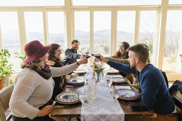A group of people toasting at a table with a view of the outdoors. - Historic Downtown Oasis with Pool (Charlottesville)