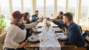 Un grupo de personas sentadas alrededor de una mesa con vistas al exterior.
