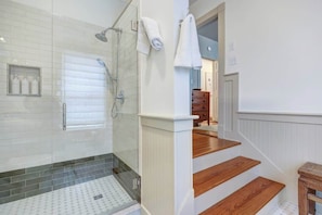 A bathroom with a shower, a toilet, and a sink.