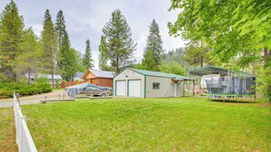 En bostadsfastighet med en stor gräsmatta, ett garage och en takförsedd uteplats.