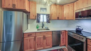 A kitchen with wooden cabinets, stainless steel appliances, a dishwasher, and a stove. - Family Fun on Ruby Creek: Cusick Hideaway w/ Dock (Cusick)