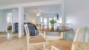 A dining area with a round table, four chairs, and a ceiling fan. - Walk to Beach: Fort Meyers Home w/ Patio! (Fort Myers Beach)