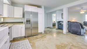 A spacious kitchen with white cabinets, a stainless steel refrigerator, and a light-colored floor. - Walk to Beach: Fort Meyers Home w/ Patio! (Fort Myers Beach)