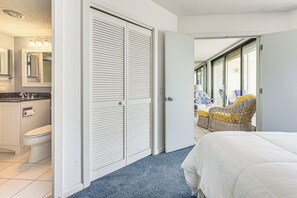 Relax in a spacious room with a large bed, separate bathroom, and sliding glass door to a balcony with outdoor seating.