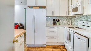 A kitchen with white cabinets, a refrigerator, an oven, and a microwave. - Salmon Return & Wildlife Roam: Ketchikan Getaway! (Ketchikan)