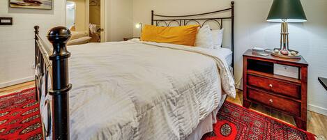 A neatly arranged bedroom with a bed, bedside table, and a lamp.