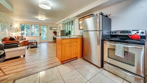 A modern kitchen with a stainless steel refrigerator, oven, and a red kettle on the stove. - 8 Mi to Dtwn Seattle: Pet-Friendly Apt w/ Hot Tub (Mercer Island)