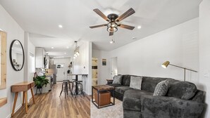 A modern living room with a gray sectional sofa, a wooden coffee table, and a ceiling fan. - Newly Rennovated • Walking Distance to Downtown • Cripple Creek Donkies (Cripple Creek)