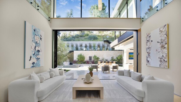 A modern living room with a large sofa set, a coffee table, and artwork on the walls. - Hutton Villa - 5-bedroom Retreat in Iconic Beverly Hills Oasis (Beverly Hills)