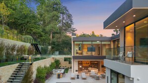 A modern two-story house with a swimming pool, outdoor seating area, and a staircase leading to a balcony. - Hutton Villa - 5-bedroom Retreat in Iconic Beverly Hills Oasis (Beverly Hills)