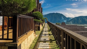 A pathway leading to a traditional-style building with a view of mountains. - HK Villa's (Sembalunbumbung)