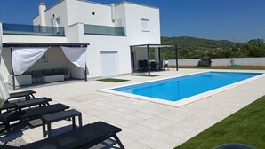 A modern house with a swimming pool, outdoor seating, and a covered patio area. - Holiday Home Iva - Three Bedroom Holiday Home (Šibenik)