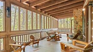 Eine Holzterrasse mit Adirondack-Stühlen und einer Steinmauer.