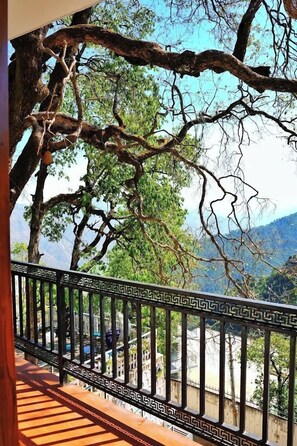 A balcony with a view of a mountainous landscape and a tree with a hanging pot. - Sarins State Side Mistville (Mussoorie)