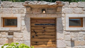 A rustic stone wall with a wooden door and two windows. - Villa Mia 2 - Six Bedroom Villa with Private Pool (Krivodol)