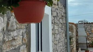 Une plante en pot suspendue à un mur de pierre.
