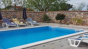 Une piscine avec des chaises longues et des parasols.