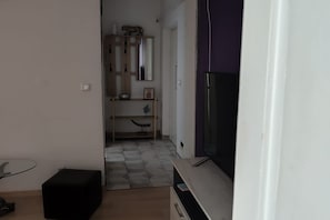 A compact living space with a television, a small cabinet, and a tiled floor. - Apartment Analea - Two Bedroom Apartment (Dubrovnik)