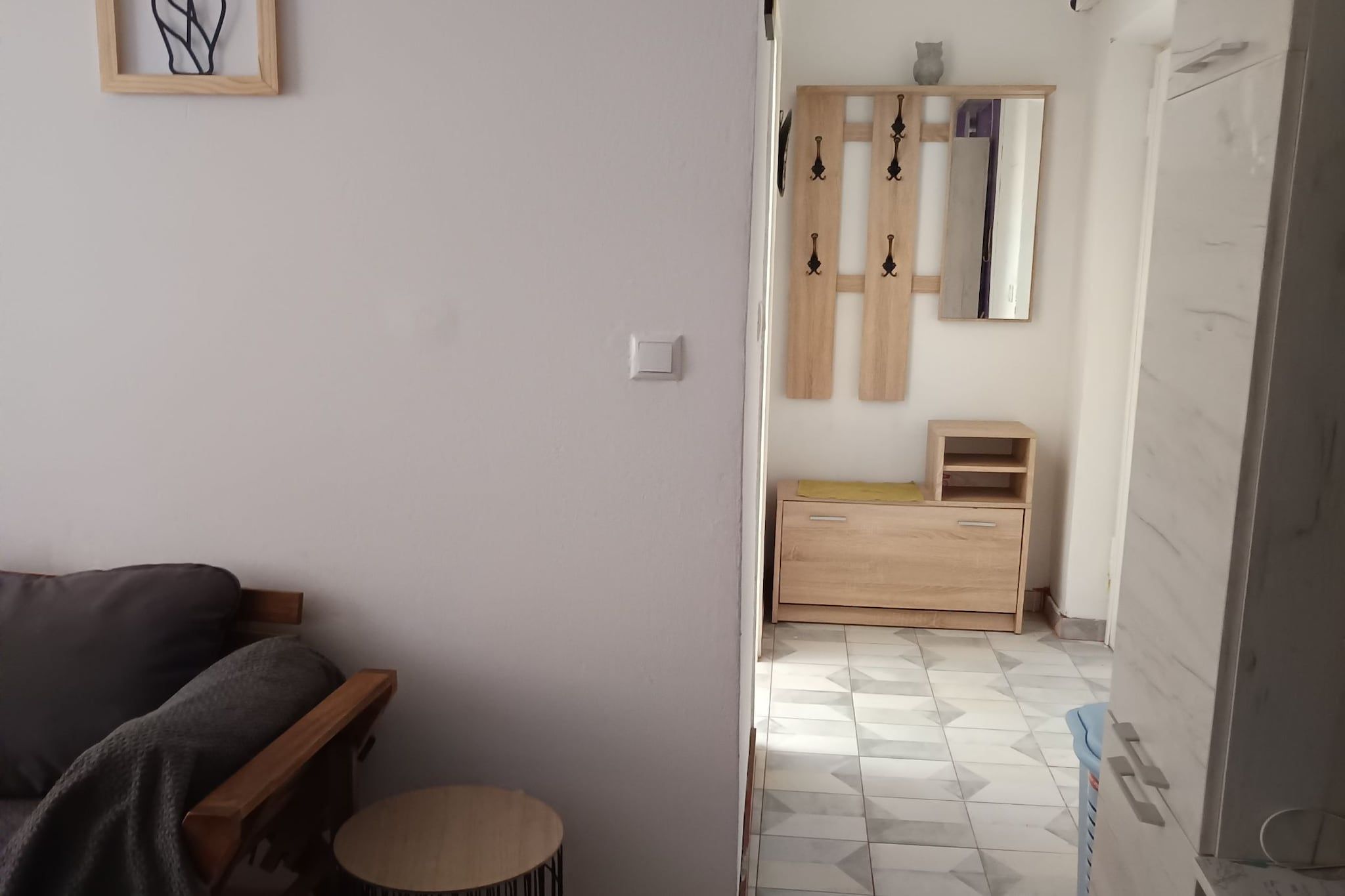 Ein Zimmer mit einem Bett, einem kleinen runden Tisch, einer Holzkommode und einem Spiegel an der Wand.
