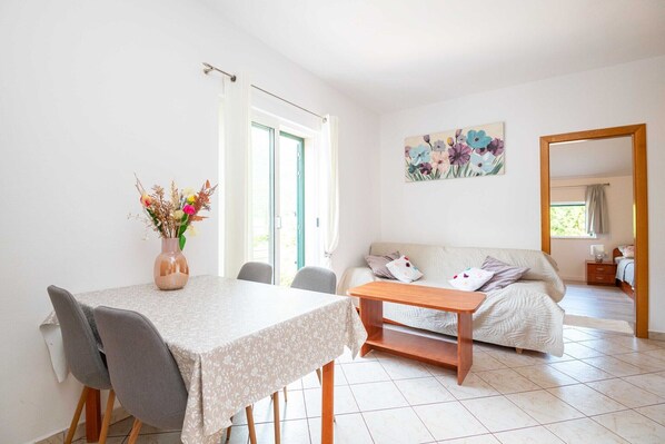 Un coin repas avec une table et des chaises, un canapé et un tableau accroché au mur.