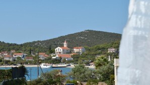 Une ville côtière avec une église imposante située sur une colline, un plan d’eau et des immeubles résidentiels environnants.