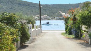 Une route côtière menant à un plan d’eau où se trouvent des bateaux.