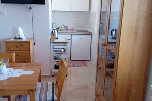 Frigorífico, placa de cocina, cafetera o tetera y mesa de comedor