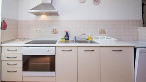 A kitchen with a dishwasher, oven, sink, and a range hood. - Apartments Bonic - Two Bedroom Apartment (Veli Losinj)