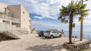 A paved driveway leading to a building with a stone staircase and a palm tree. - Apartments Bregha - Three Bedroom Apartment with Terrace (Matulji)