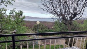 A balcony with a checkered table, a lamp post, and a view of a lake and mountains. - Holiday Home Marina - Two Bedroom Holiday Home with Terrace (Starigrad)