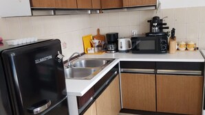 A compact kitchen with a refrigerator, microwave, coffee maker, and a sink. - Holiday Home Marina - Two Bedroom Holiday Home with Terrace (Starigrad)
