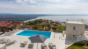A rooftop pool with a clear view of the sea and surrounding buildings. - Apartments Bregha - One Bedrom Apartment with Terrace (Matulji)