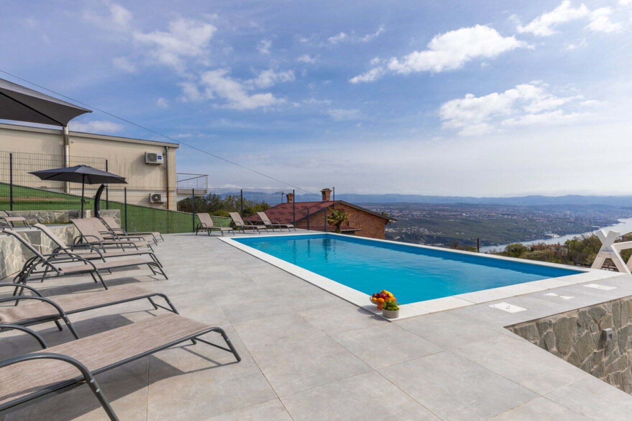 Une piscine dotée de chaises longues et offrant une vue sur le paysage.