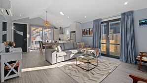 Un salon moderne avec un canapé, une table basse et une vue sur la cuisine et l’espace repas.