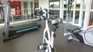 A gym with various exercise equipment, including treadmills, ellipticals, and a stationary bike.
