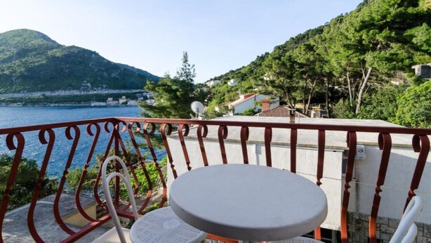 A balcony with a round table and chairs overlooking a body of water and a mountainous landscape. - Guest House Sobra 38 - Studio with Balcony and Sea View (Sobra)