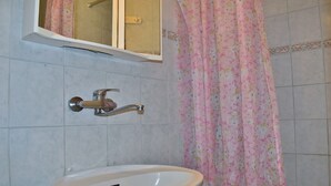 A bathroom with a sink, faucet, and a shower curtain. - Apartments Jug - Comfort Studio Apartment with Balcony and Sea View (Lopar)