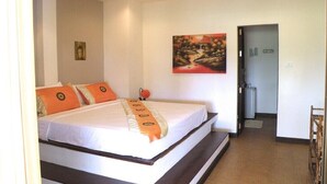 A bedroom with a bed, a painting on the wall, and a door leading to another room. - PINK HOUSE (Koh Samui)