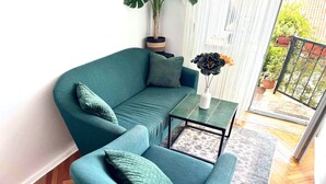 A teal-colored sofa and armchair set with matching cushions, a small side table, and a potted plant. - Charming Apartment with Terrace and Old Town View - One Bedroom Apartment with Terrace (Dubrovnik)