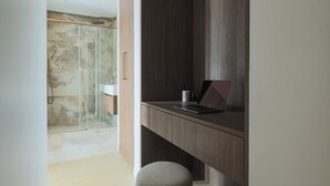 A modern bathroom with a glass shower enclosure, a wooden vanity with a laptop, and a marble-tiled wall. - Elegant apartment - 3BR-8P- Le Marais (Paris)