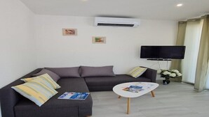 A modern living room with a grey sectional sofa, a white coffee table, and a flat-screen TV mounted on the wall. - Luxury apartment Ani II  - Two Bedroom Apartment with Terrace (Sutivan)