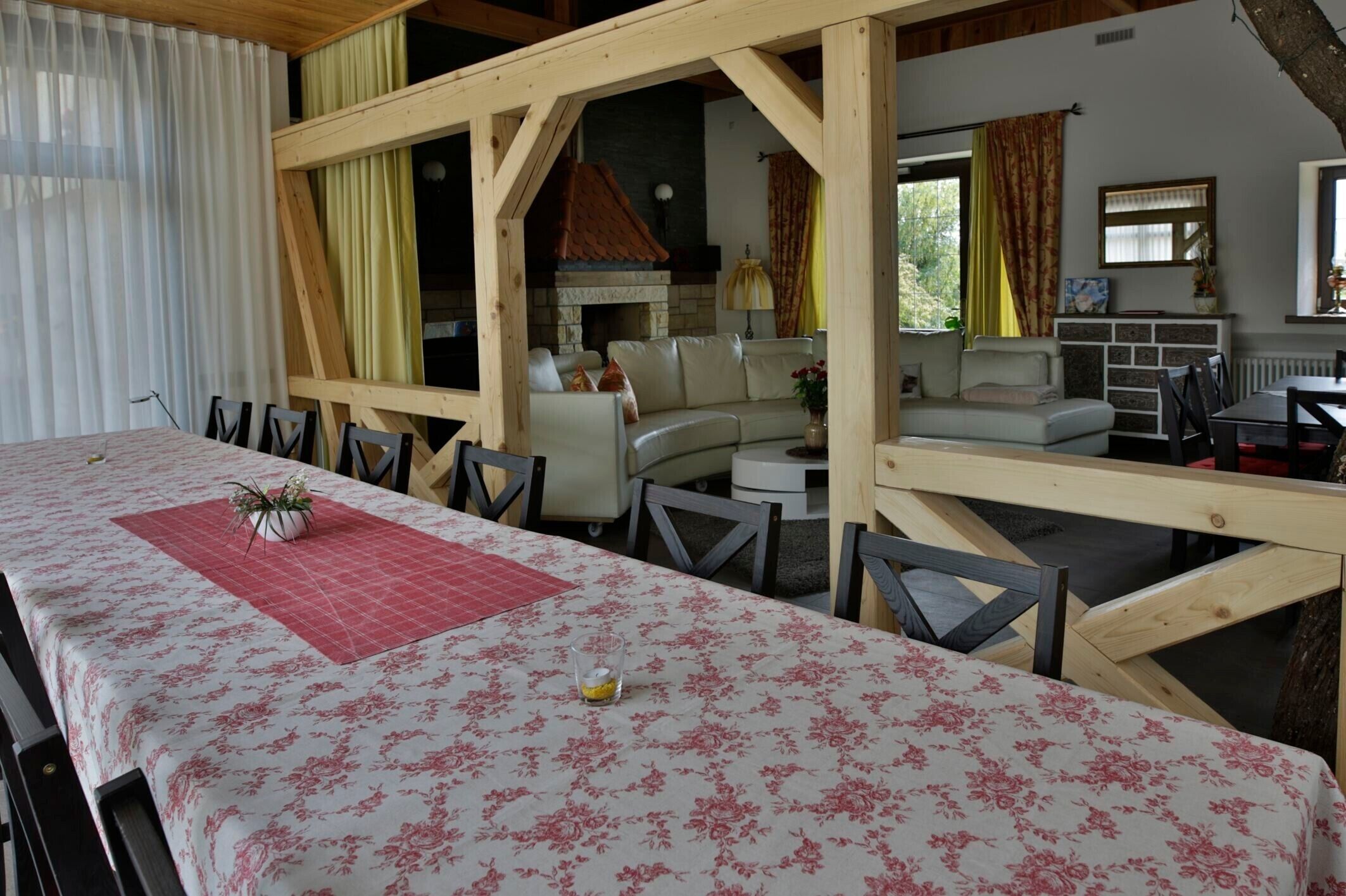 Een eetruimte met een tafel voor twee personen, een open haard en een bank op de achtergrond.