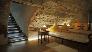 Ein Schlafzimmer mit Stewand, einem Bett mit Kissen, einem Nachttisch mit Lampe und einer Treppe.