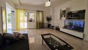 Un salon moderne avec un canapé, une table basse, un téléviseur et une plante.